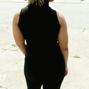 Sleeveless black mock turtle neck top.